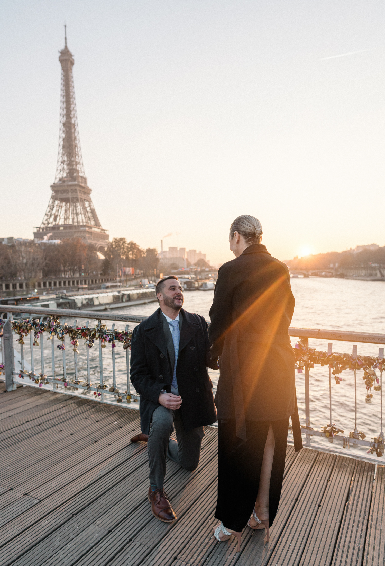 man proposes to woman on passerelle debilly in paris at sunset in december