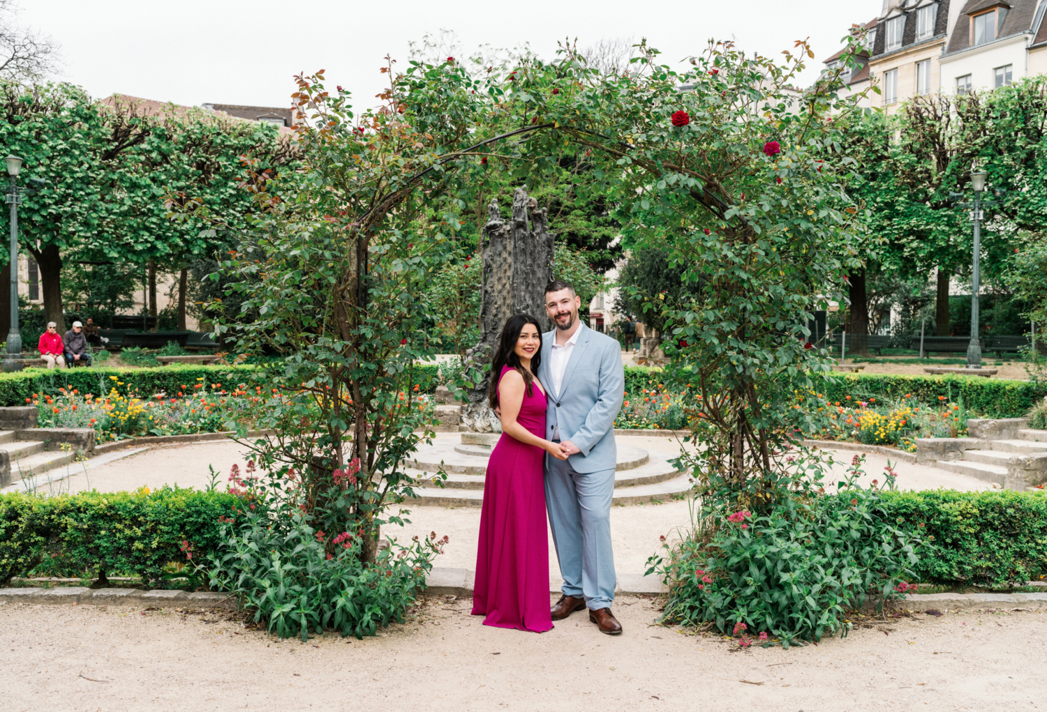 happy couple pose outside paris garden