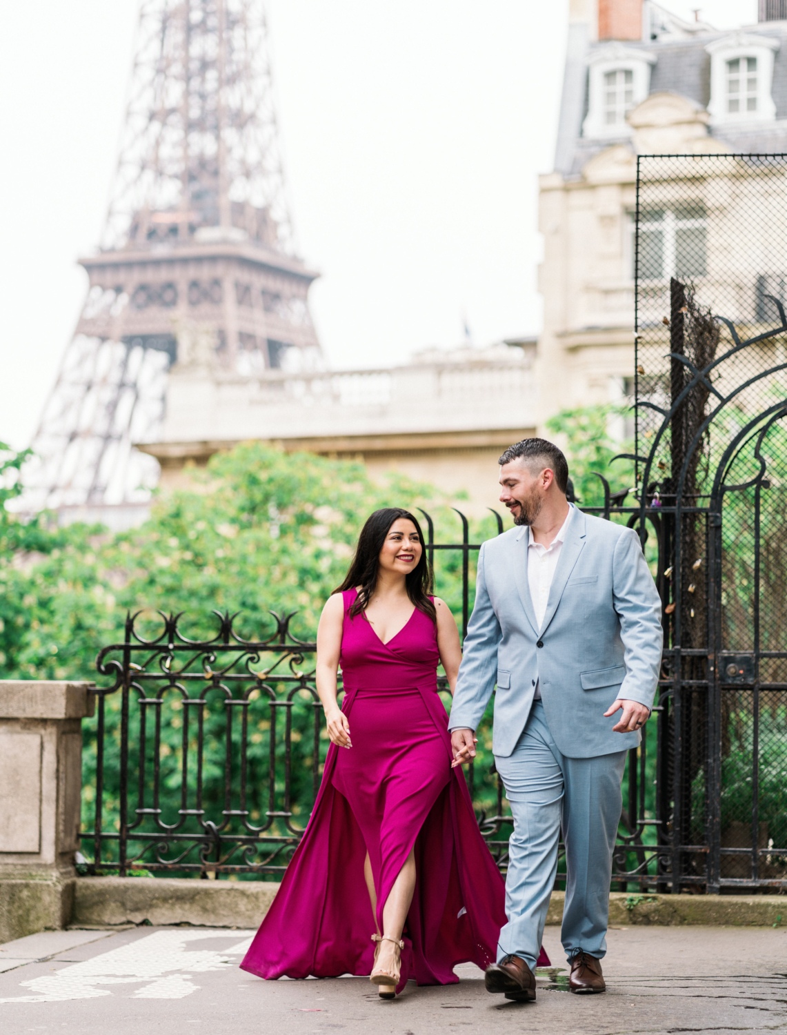 gorgeous couple walk hand in hand with eiffel tower in background