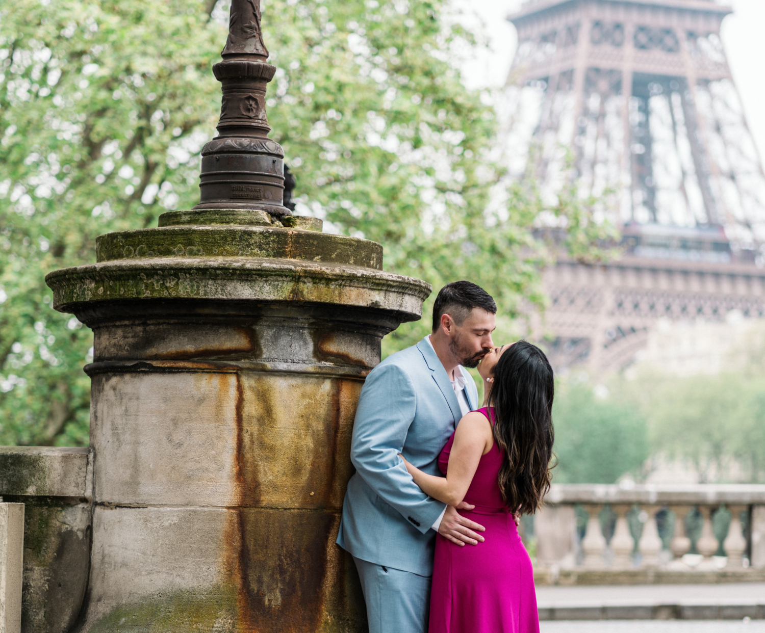 married couple kiss with view of eiffel tower in paris in background