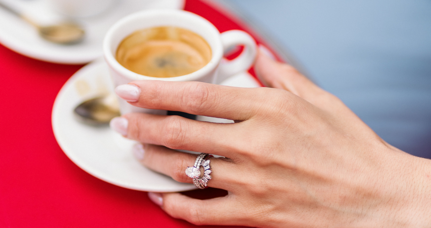 woman shows off wedding ring with espresso in paris