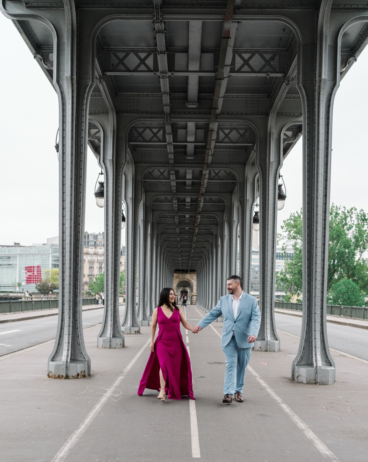 gorgeous couple walk under pont bir hakeim in paris