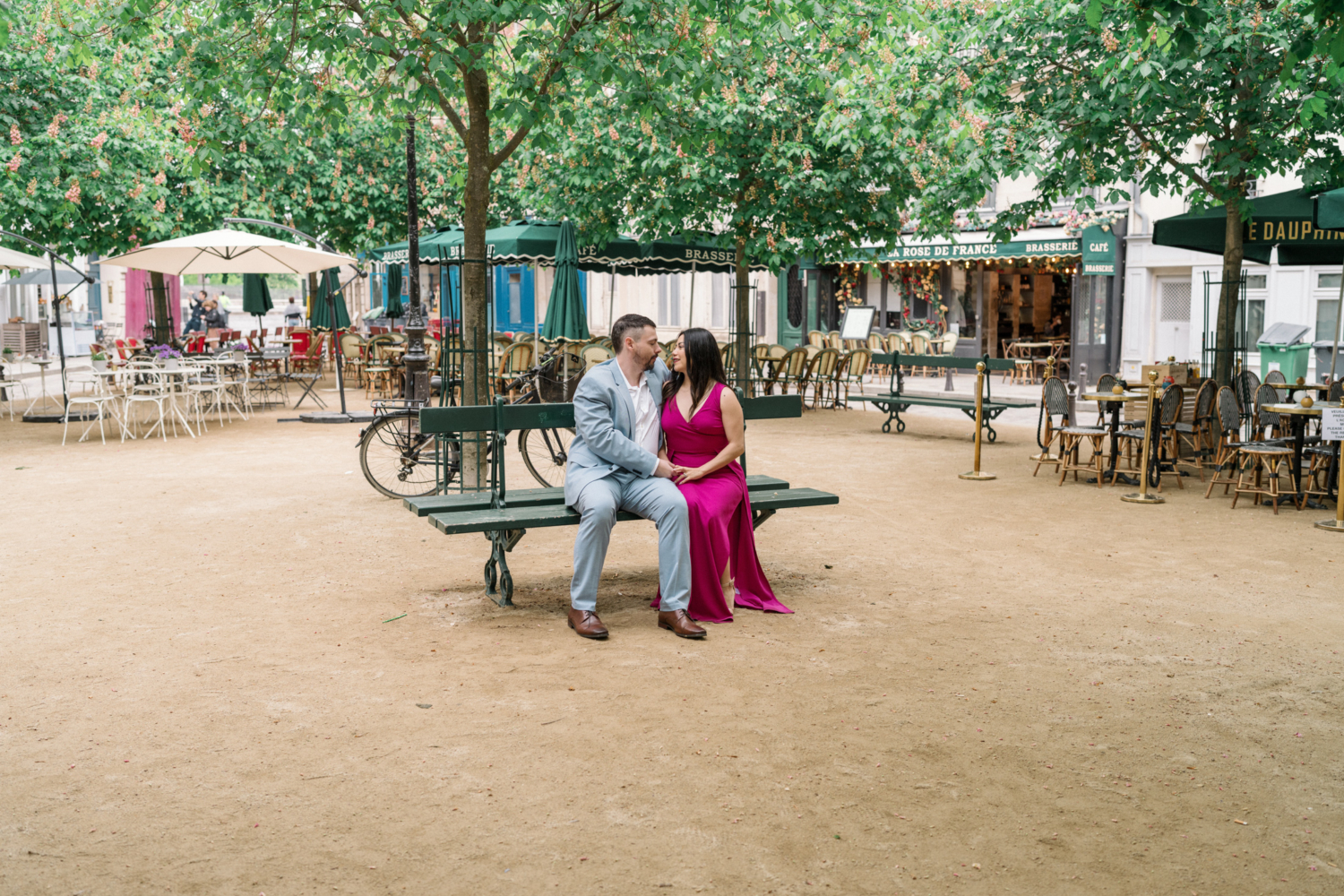 husband and wife sit on bench in paris