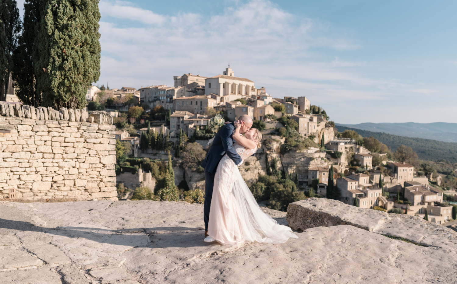 bride and groom passionately kiss in gordes france provence