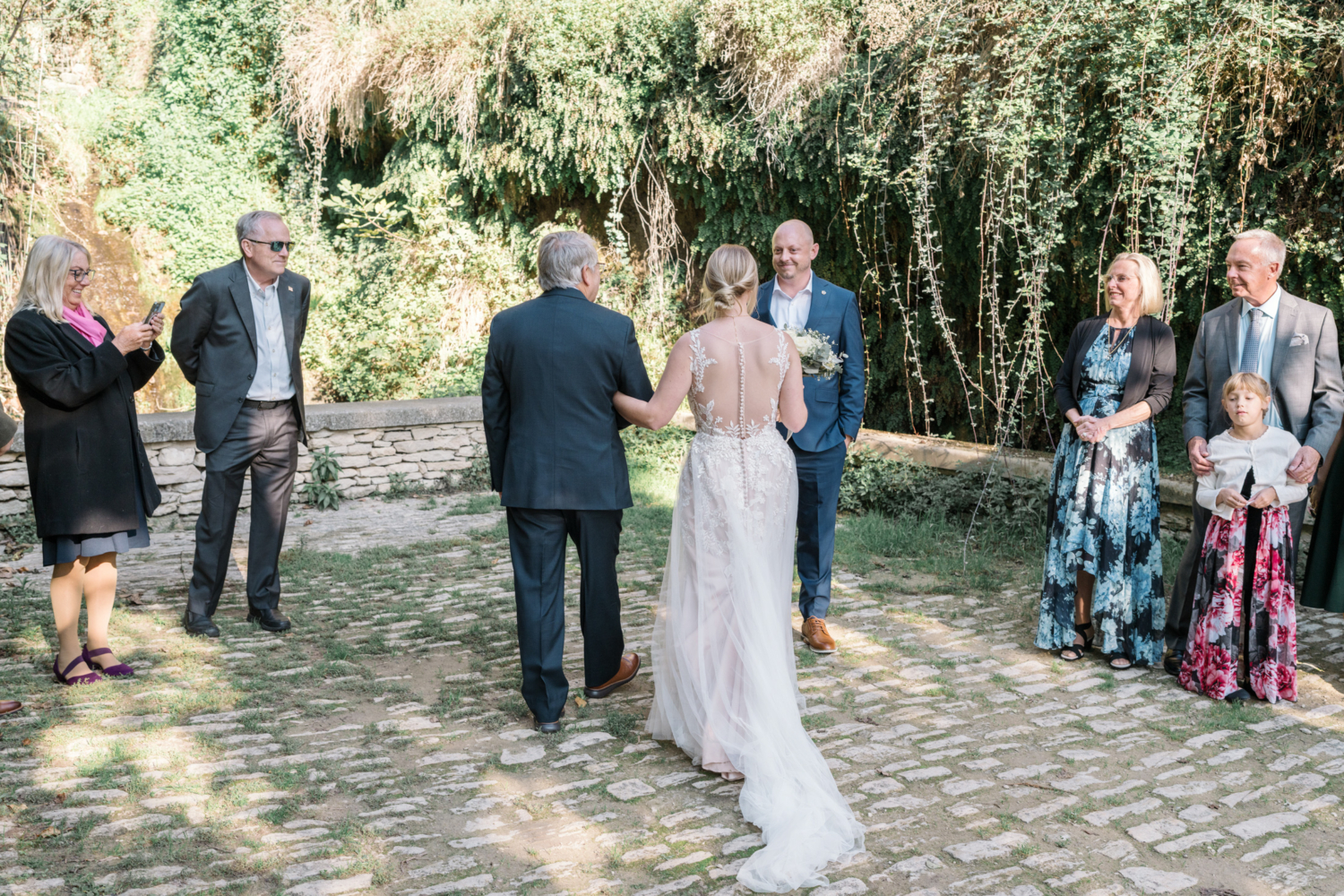 bride is walked to groom by her father for wedding ceremony in gordes france provence