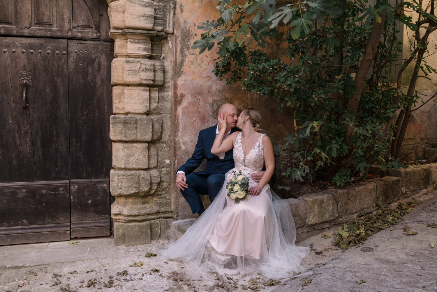 bride embraces groom on the streets of gordes france in provence