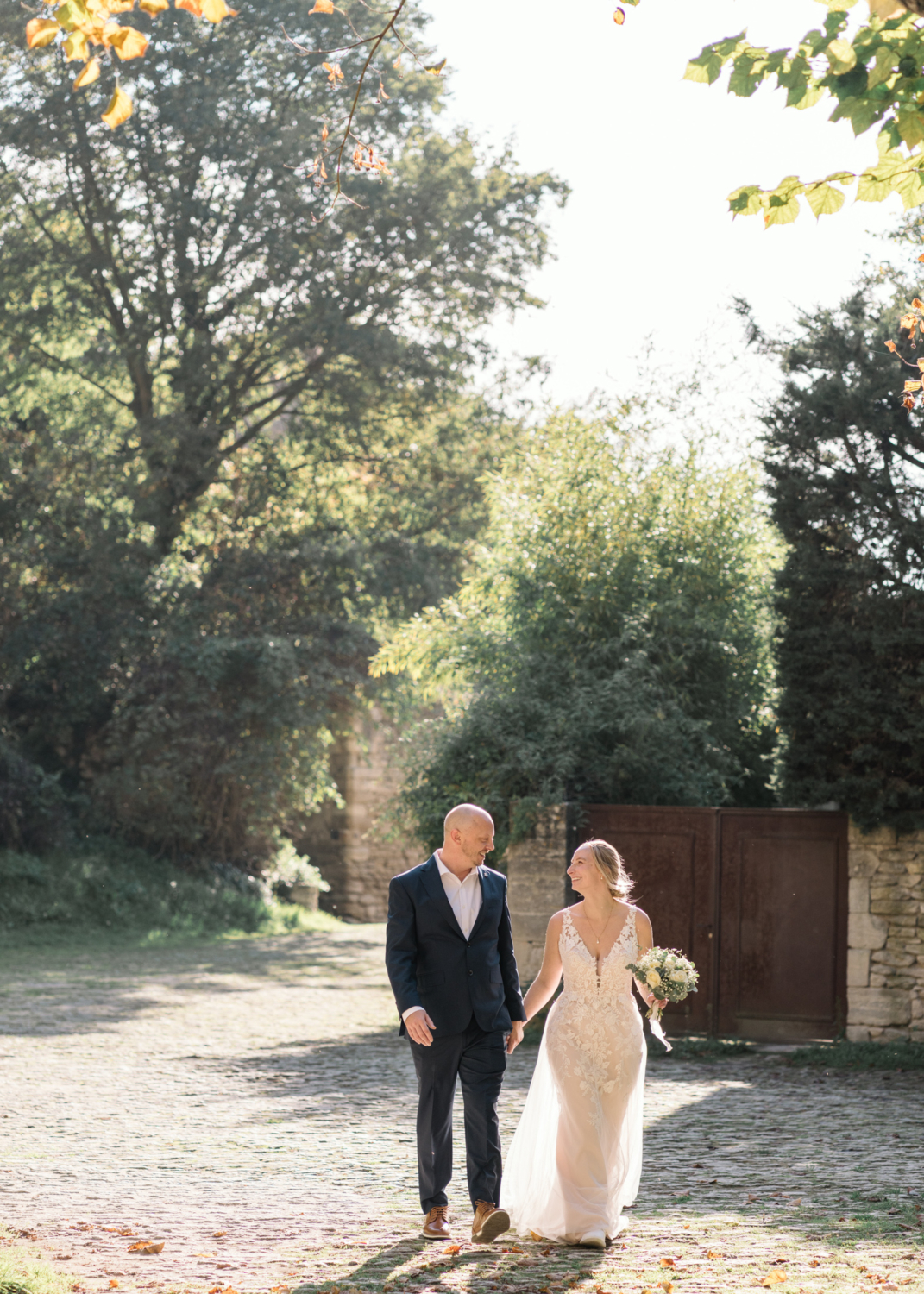 happy bride and groom walk hand in hand in gordes france