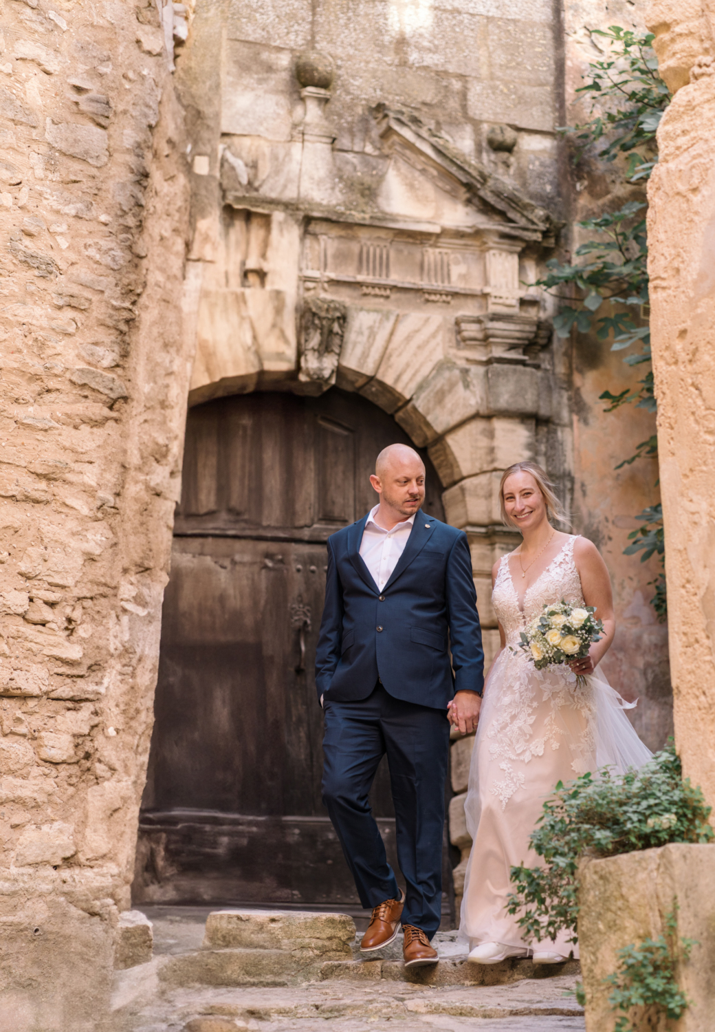 bride and groom walk down ancient staircase in gordes france