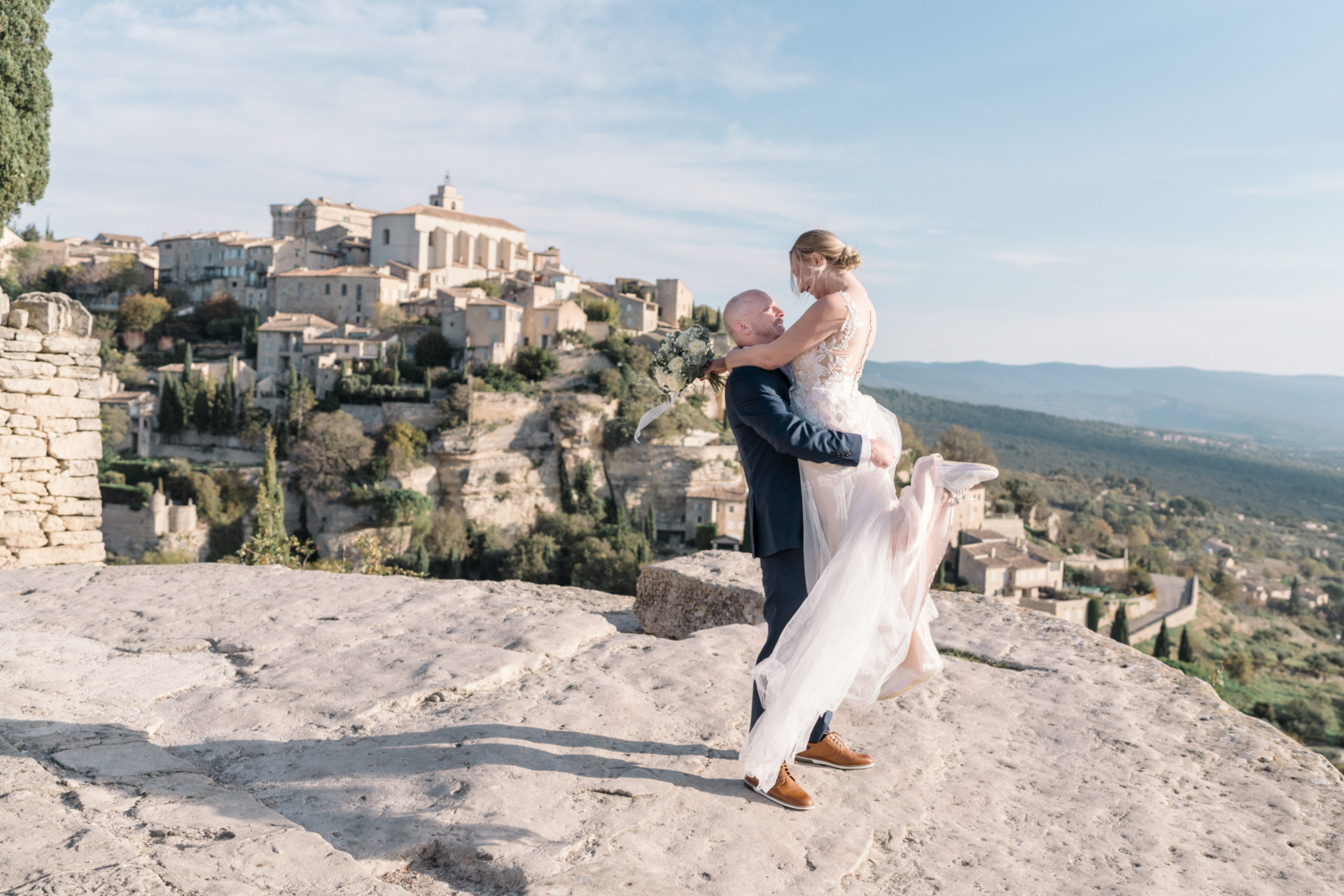 groom lifts bride on their wedding day in gordes france provence