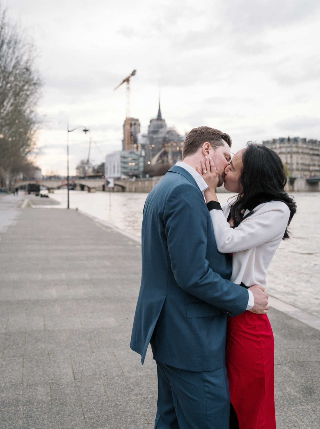 newly engaged couple kiss passionately along the banks of the seine river in paris