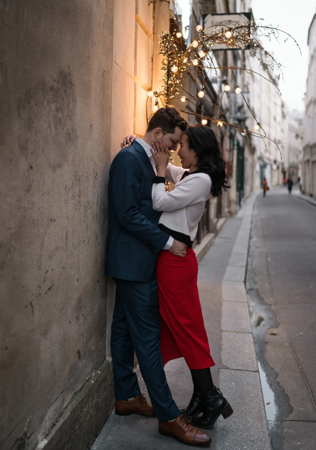 newly engaged couple embrace in the latin quarter in paris