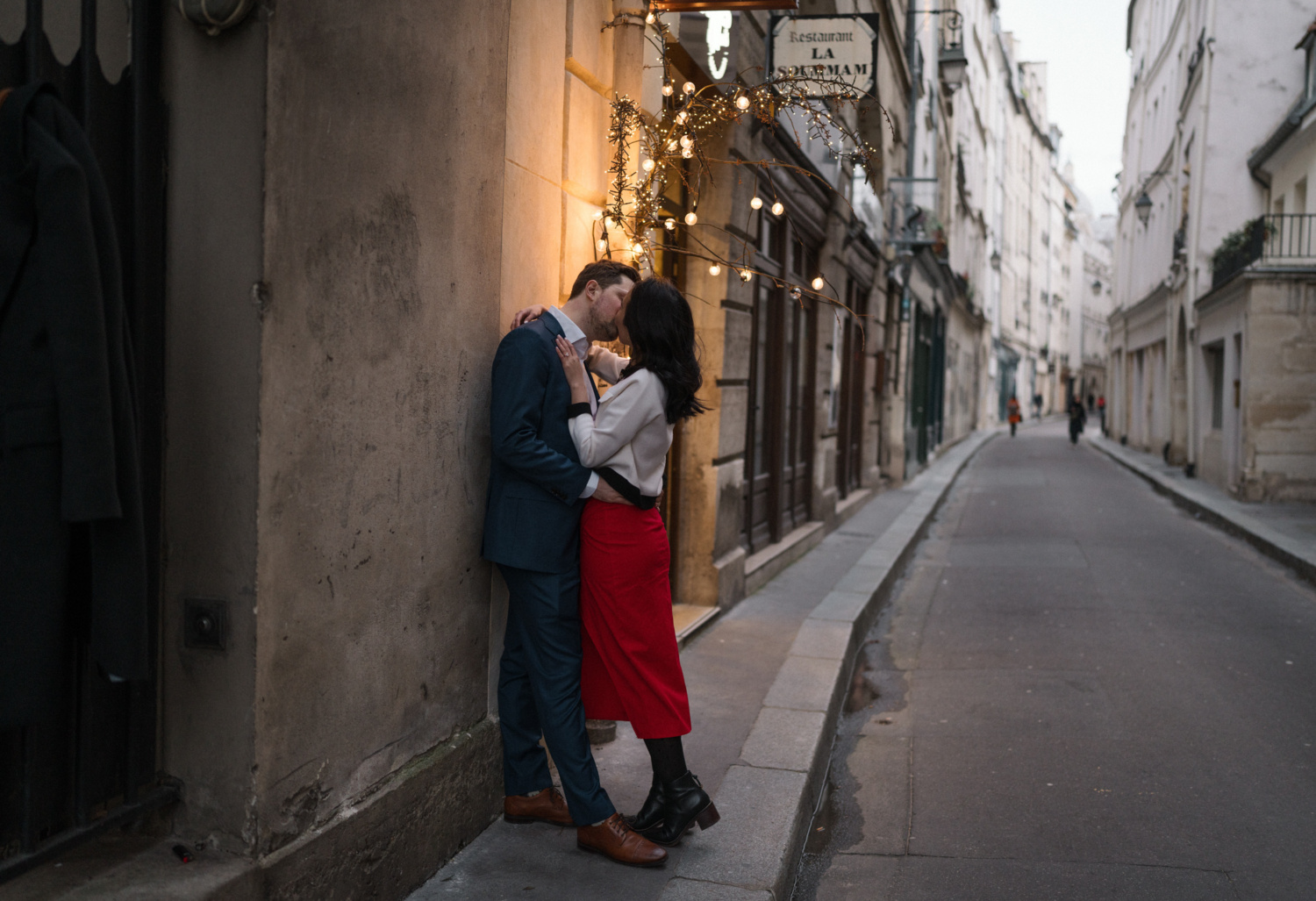 newly engaged couple kiss passionately on charming street in paris