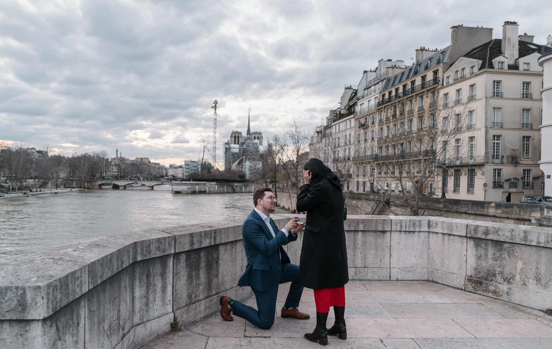 man proposes to woman on pont de la tournelle in paris