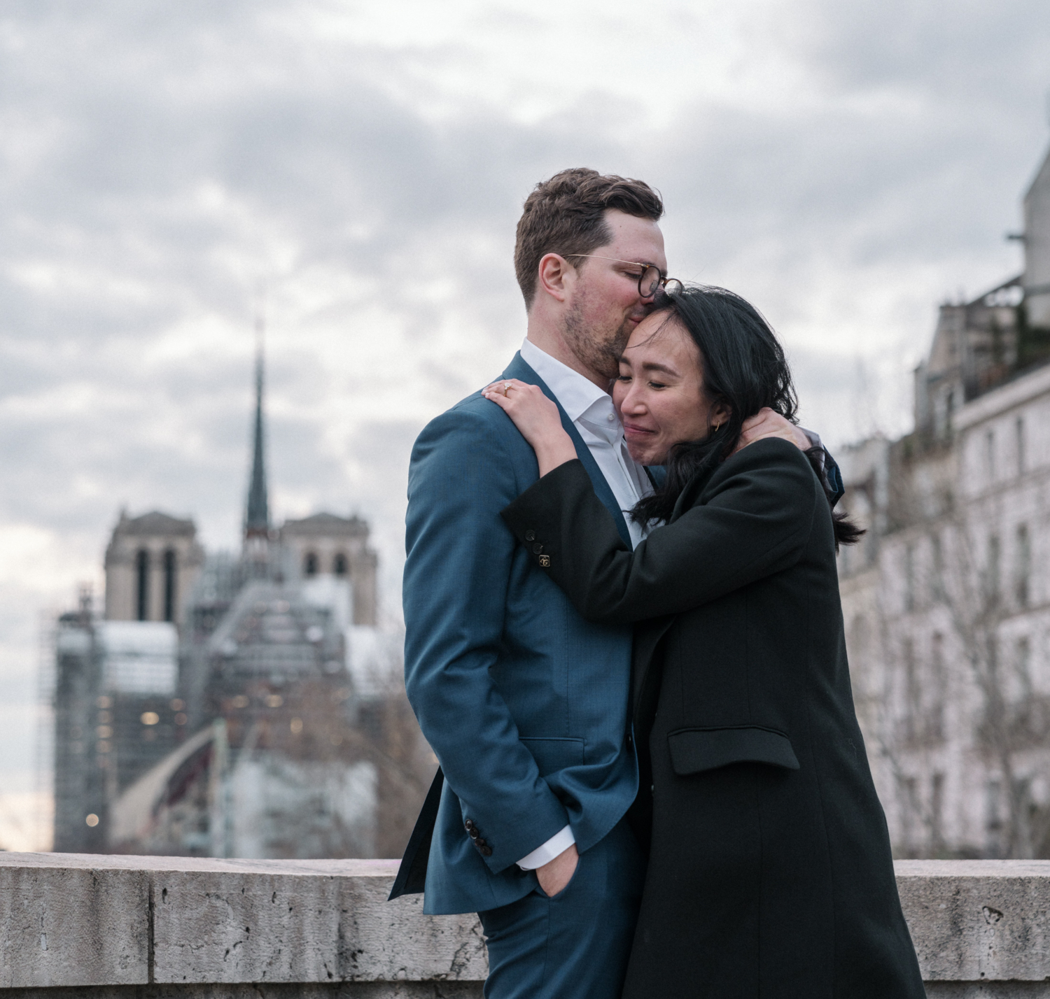 newly engaged couple embrace after surprise proposal in paris