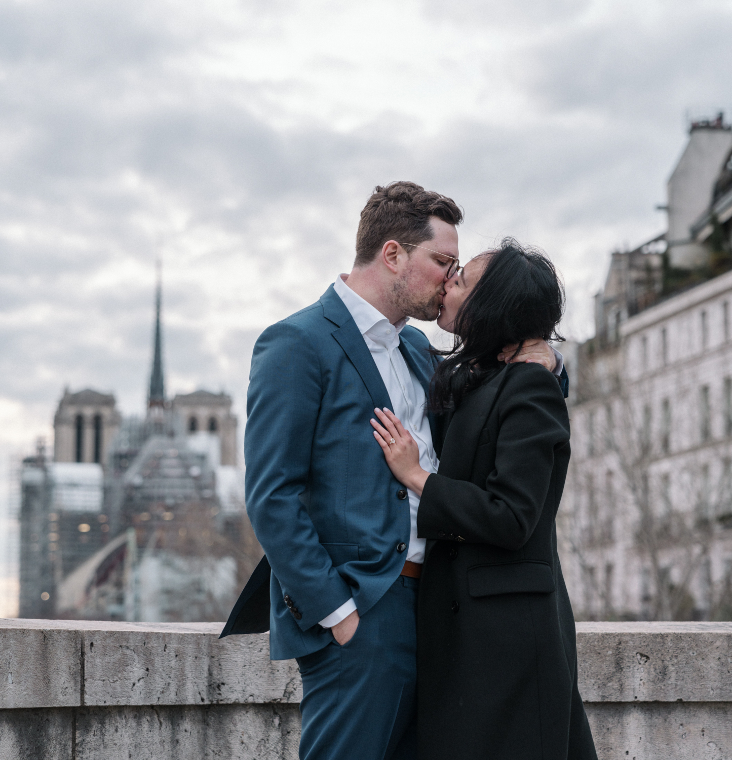 newly engaged couple kiss passionately after their surprise proposal in paris