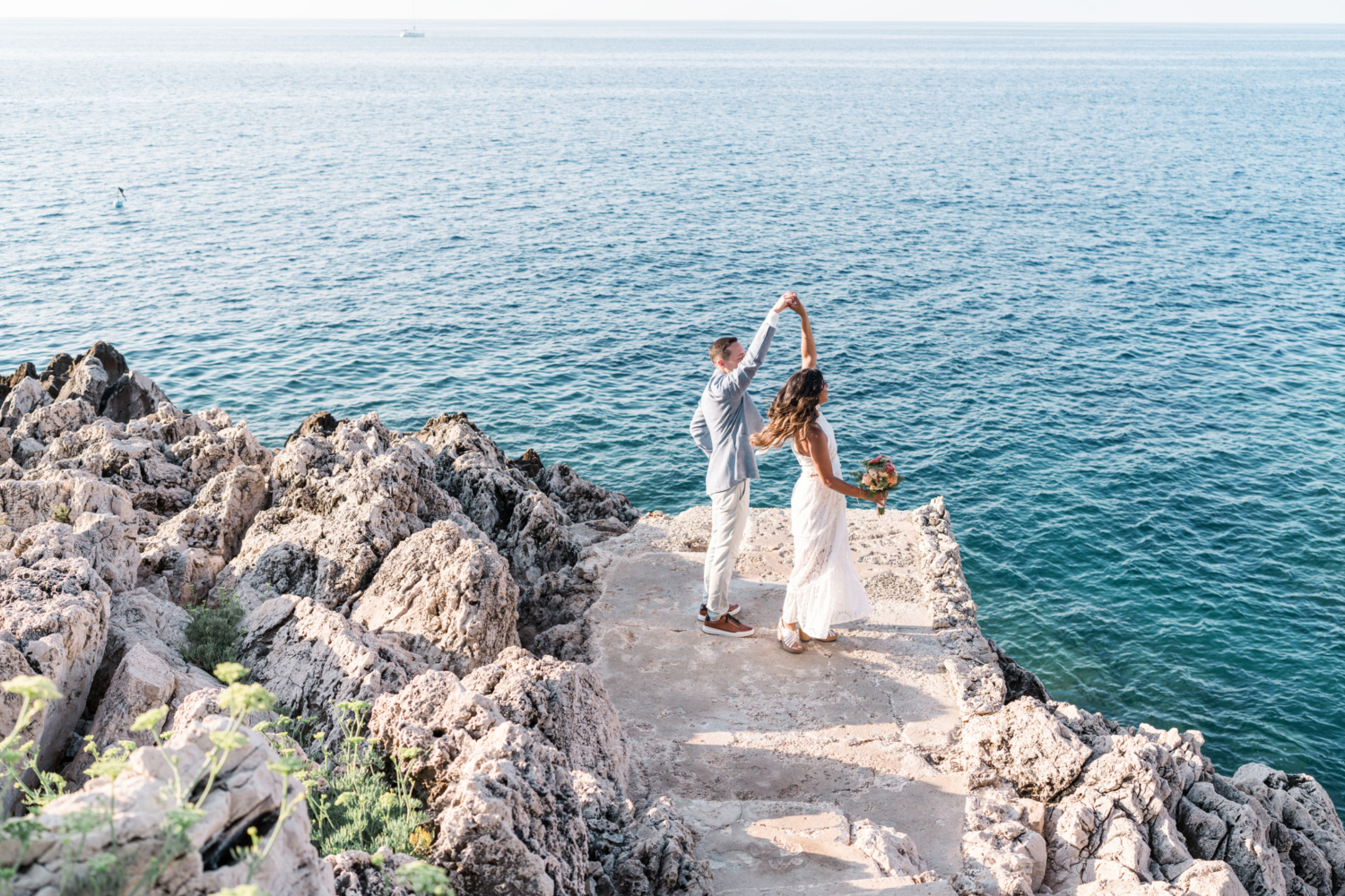 bride and groom twirl with sea view in saint jean cap ferrat france on the french riviera