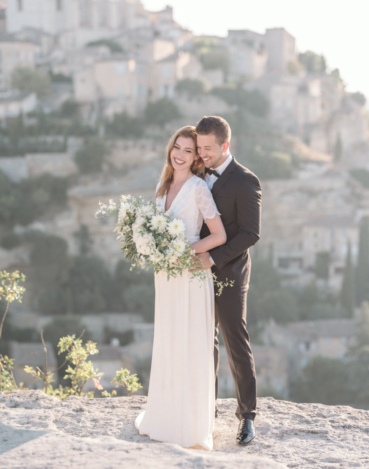 bride and groom laugh as they pose for wedding photos in gordes france