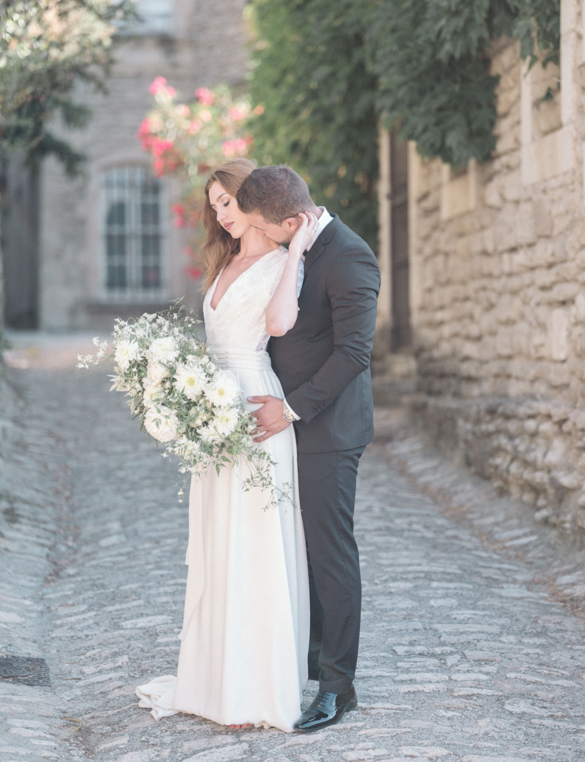 bride and groom pose on the streets of gordes france