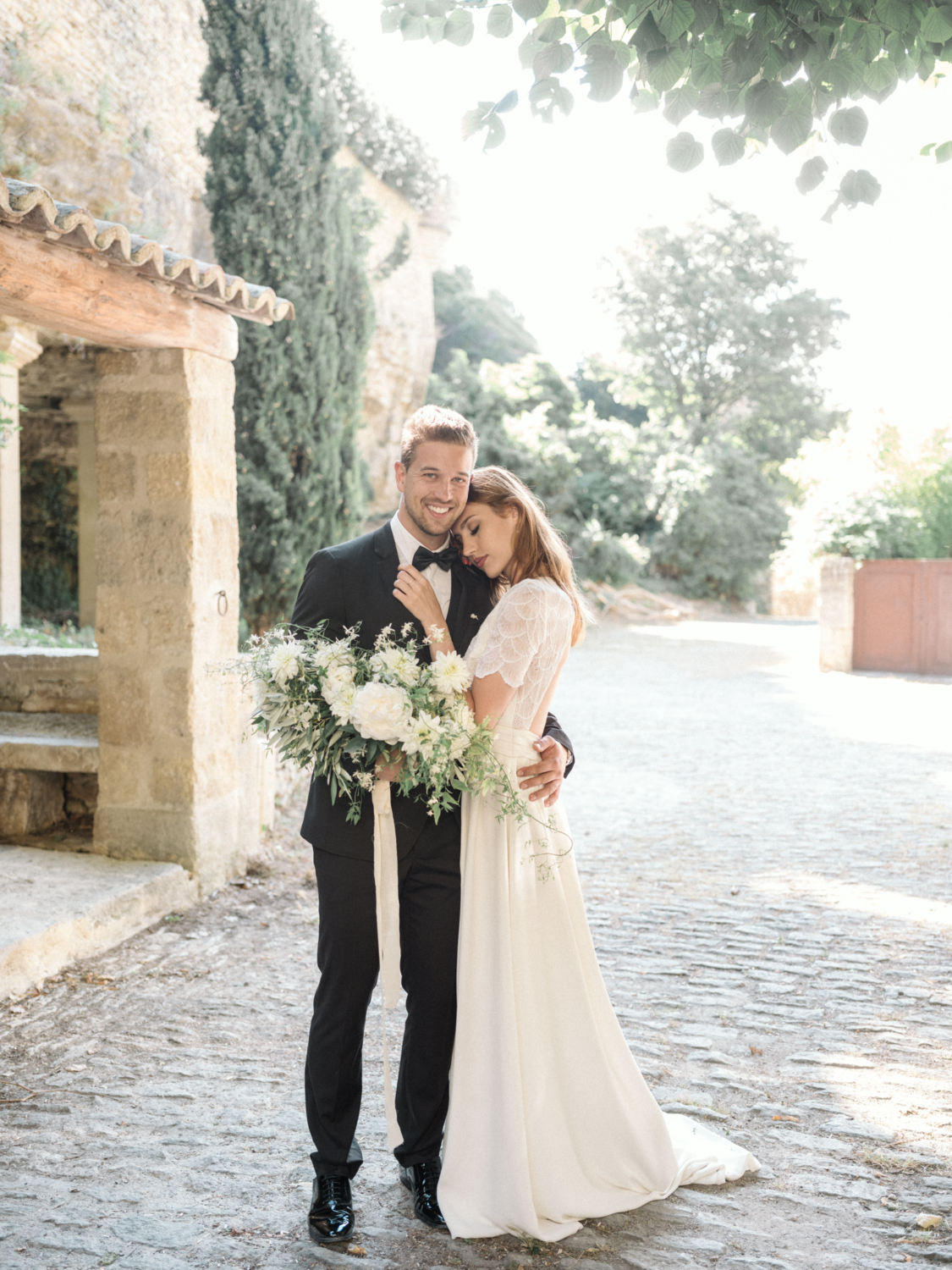 bride and groom embrace and smile on their wedding day in gordes france