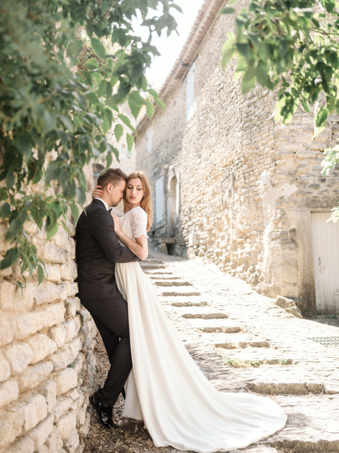 bride and groom embrace on cobblestone street in gordes france