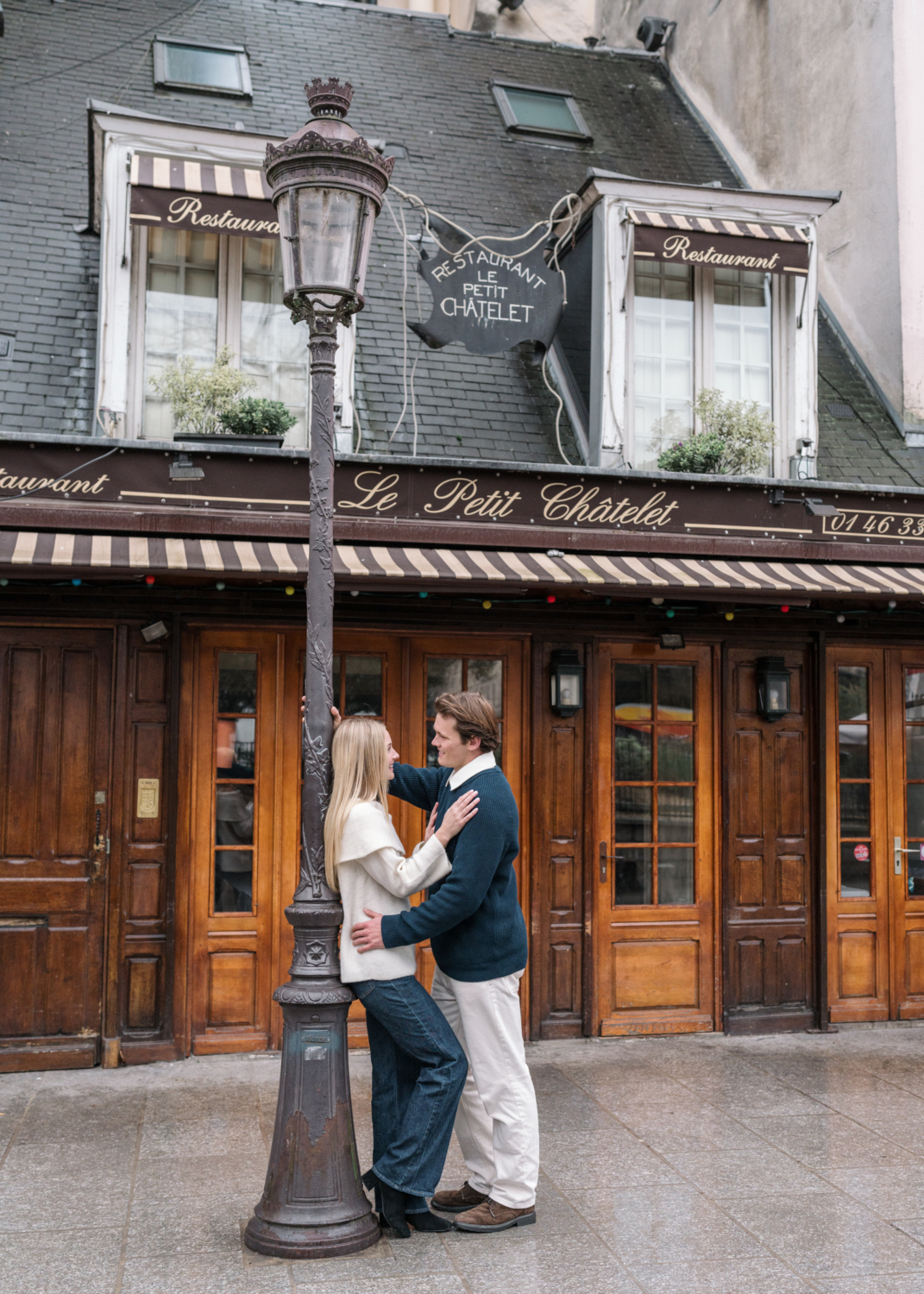 newly engaged couple pose in front of le petit chatelet in paris