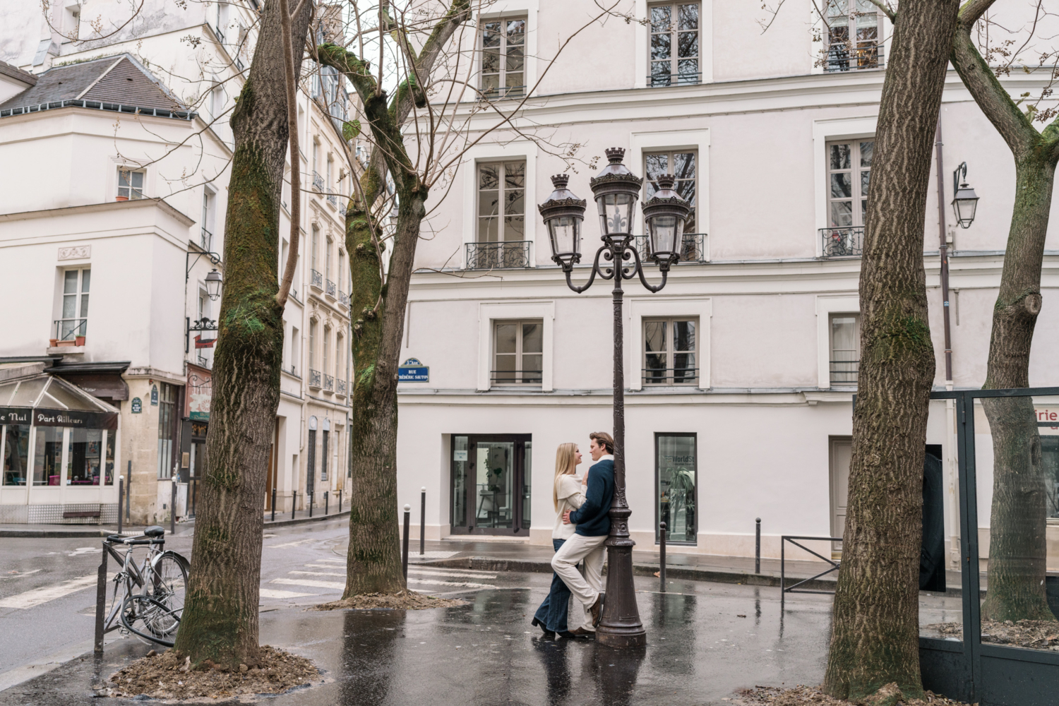 newly engaged couple embrace in cute parisian neighborhood