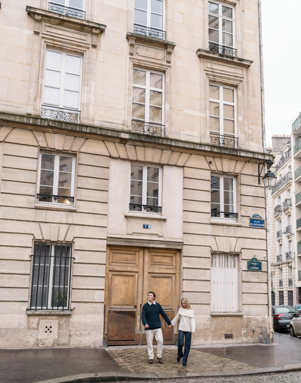 newly engaged couple walk in front of emily's apartment from emily in paris