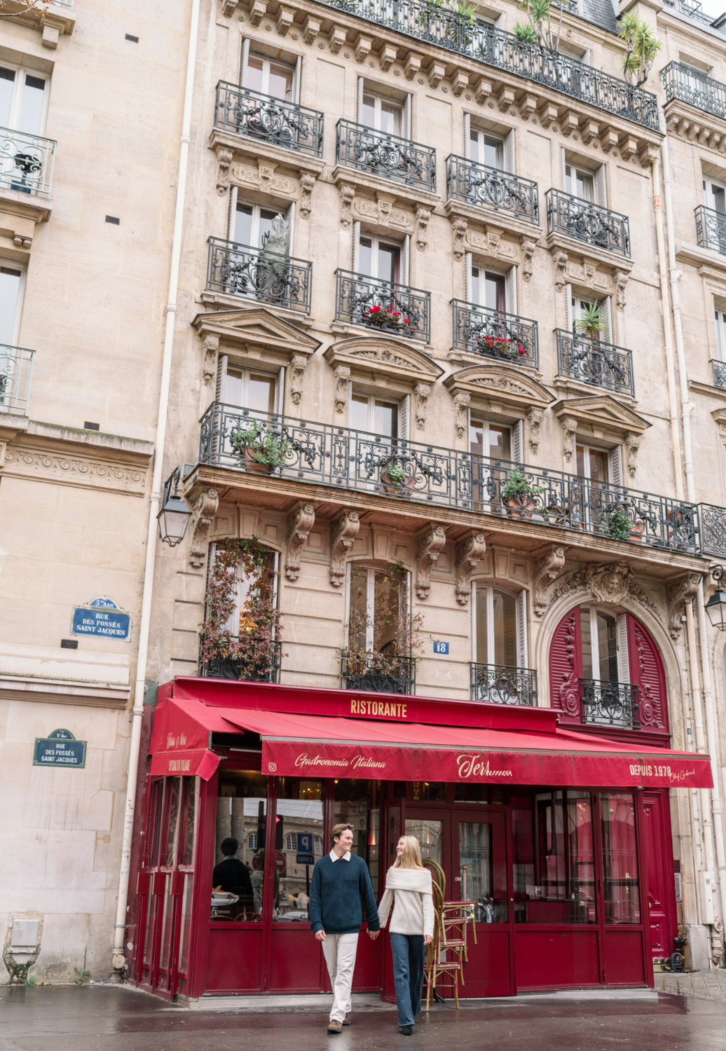 newly engaged couple walk in front of restaurant featured on emily in paris