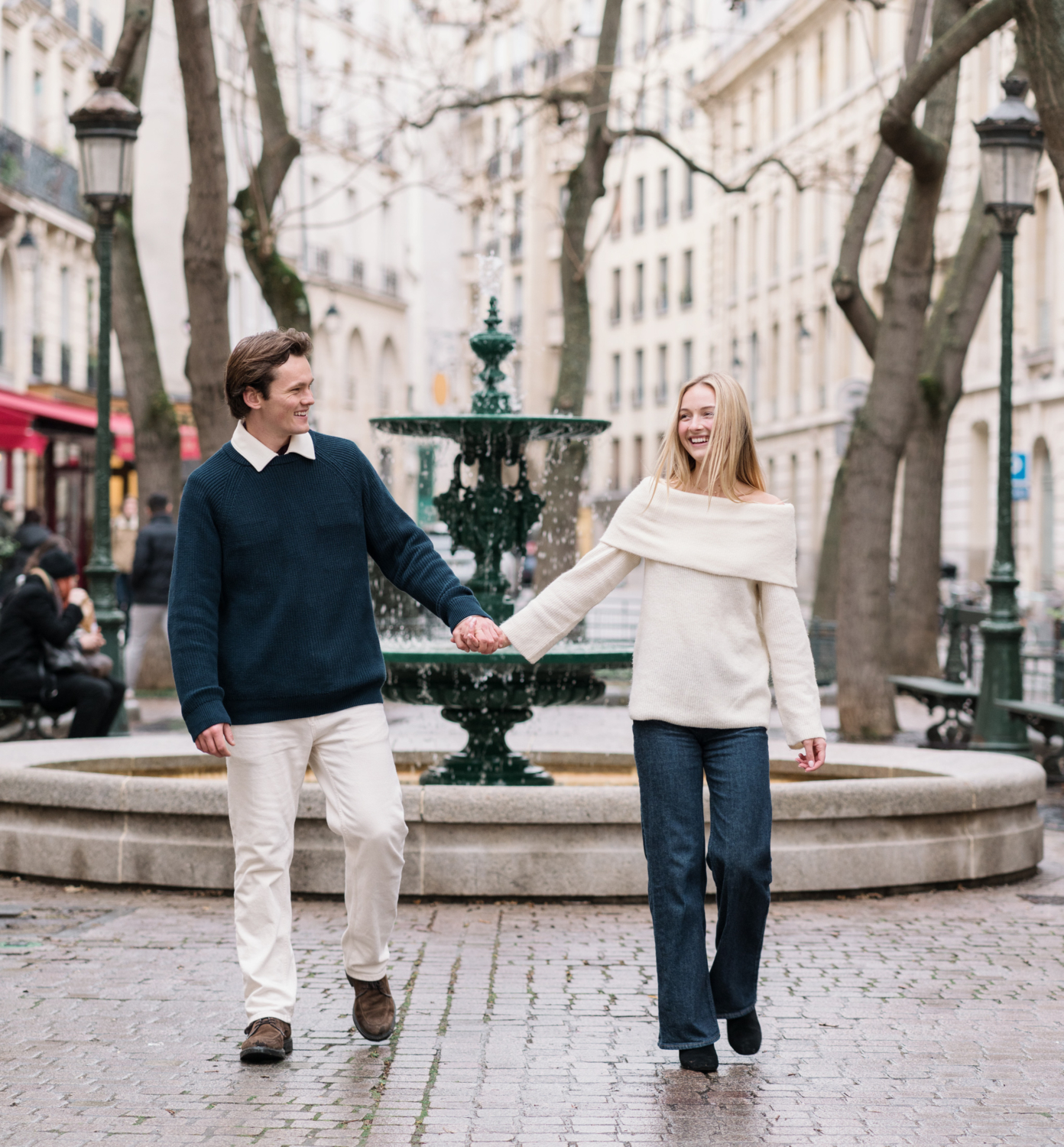 newly engaged couple laugh as they walk in charming parisian neighborhood