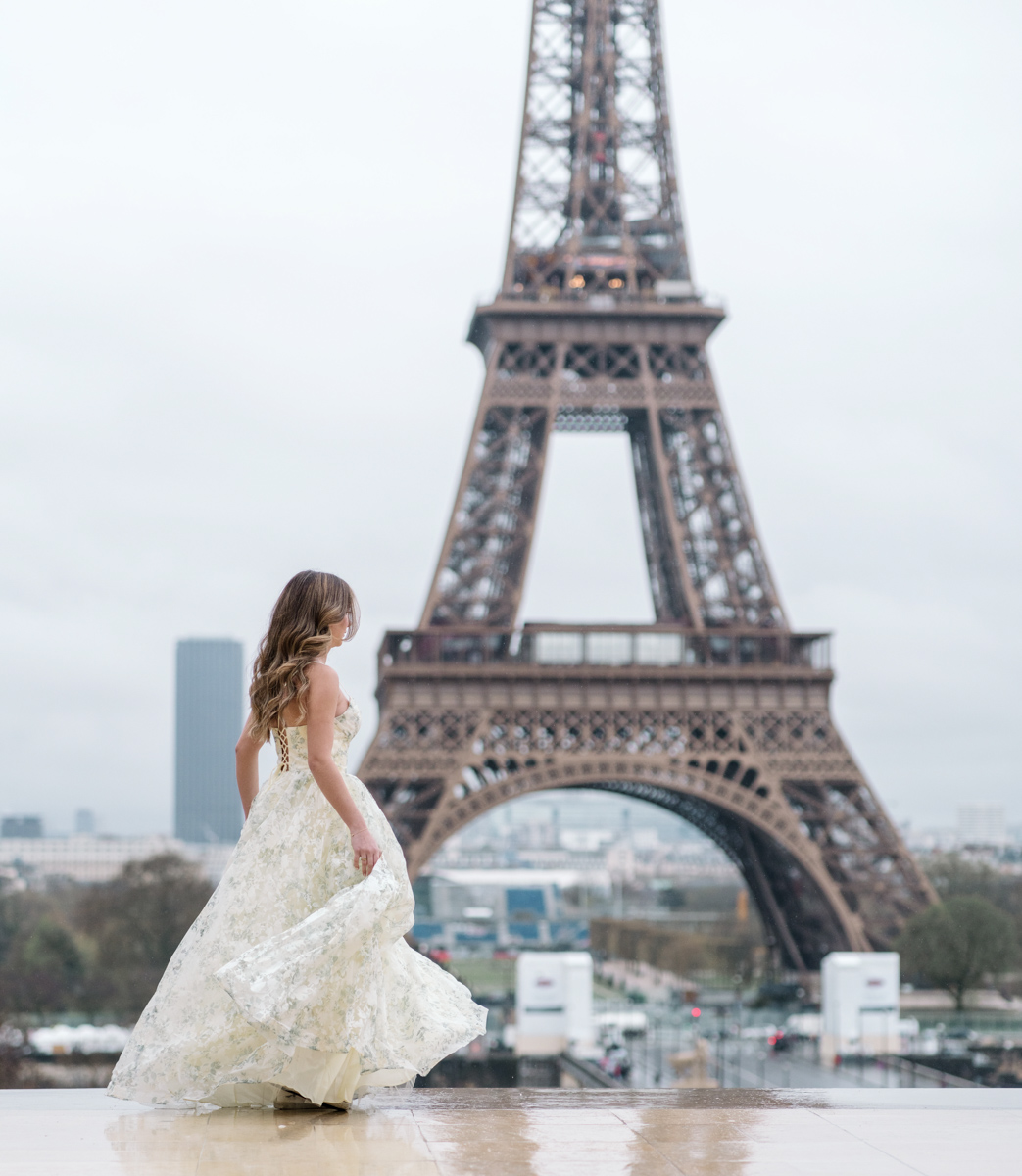 young woman dances at the eiffel tower during her quinceanera photo shoot in paris