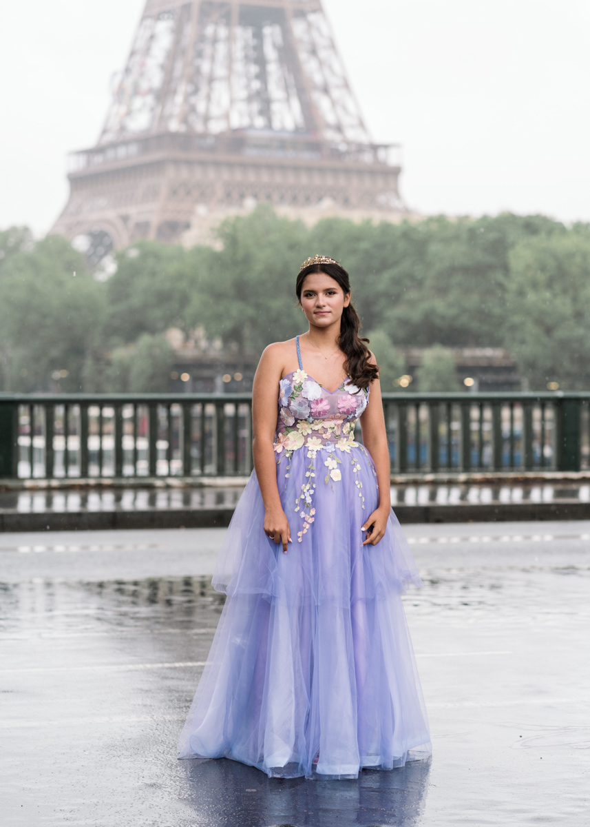 young woman in long purple gown poses in paris with eiffel tower