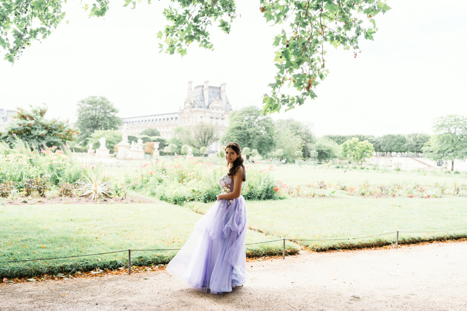 young woman poses in tuileries gardens in paris for her quinceanera