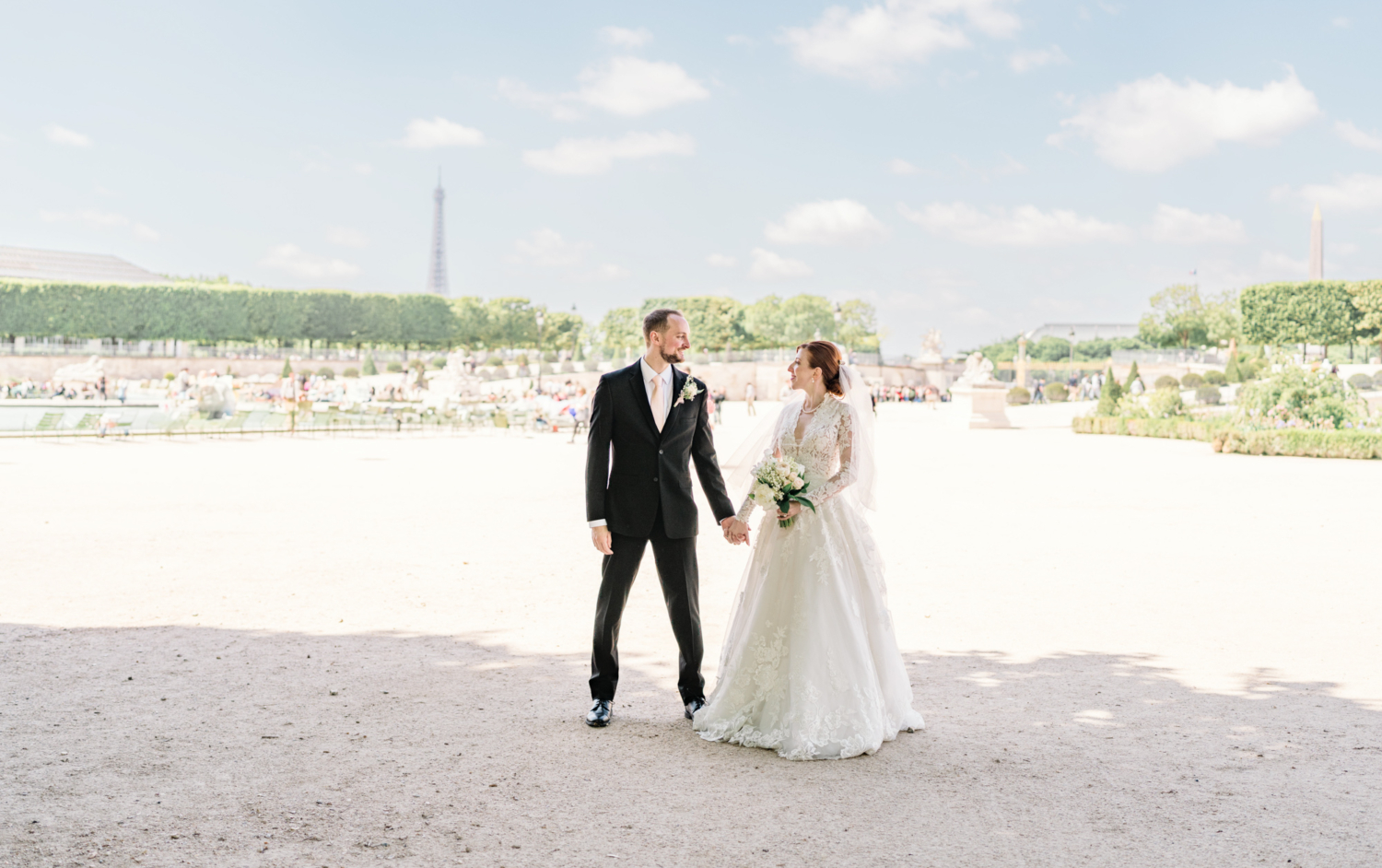 newlyweds walk through the tuileries gardens