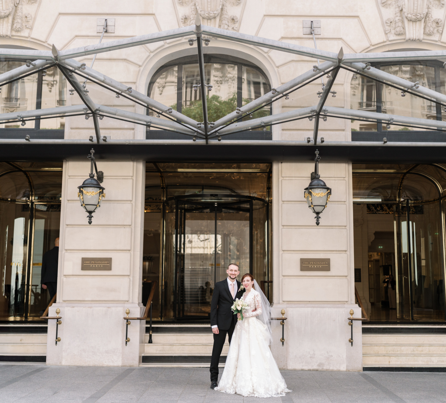 bride and groom pose on their wedding day in front of peninsula hotel paris