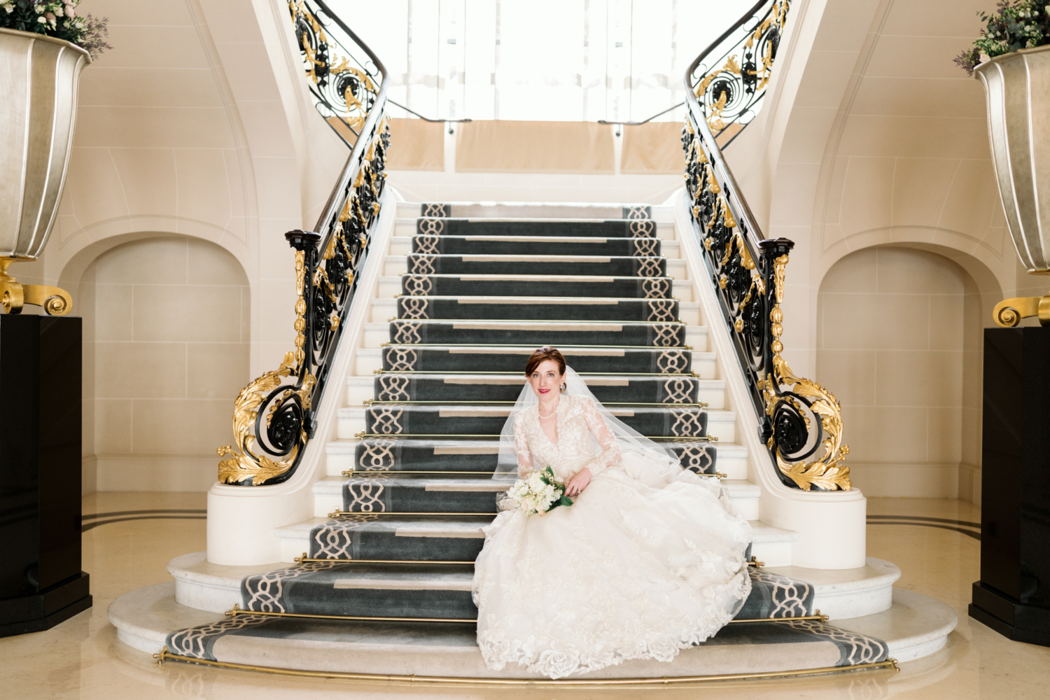 bride poses on elegant staircase at peninsula hotel paris