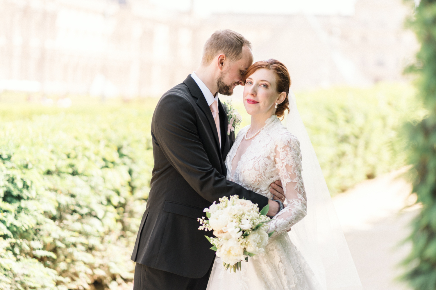 bride and groom embrace in the tuileries gardens after their wedding