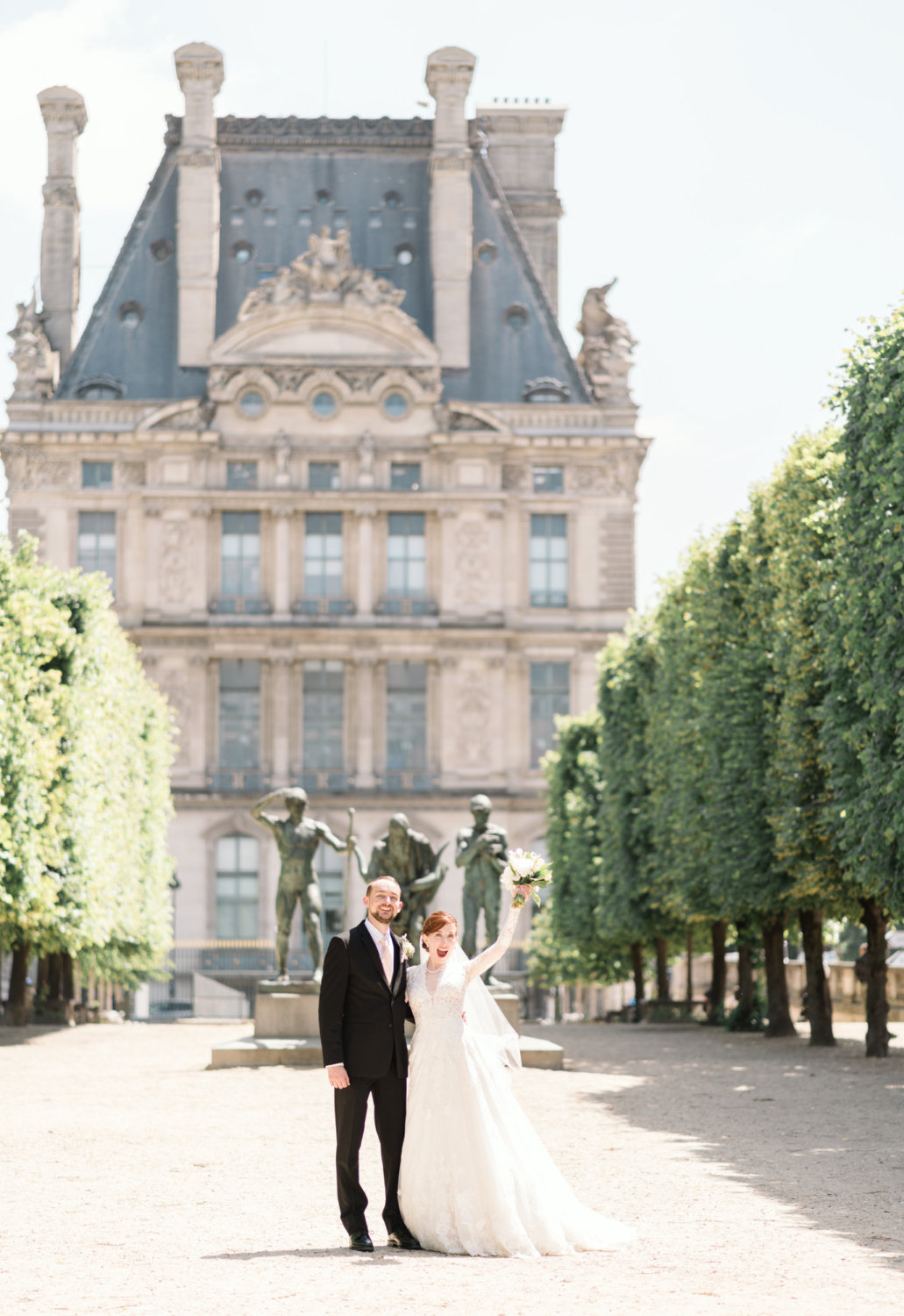 happy newlyweds pose in the tuileries gardens in paris
