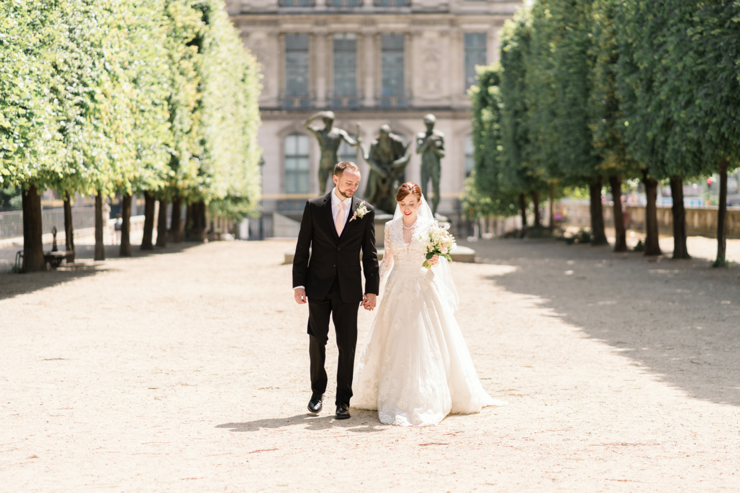 newlyweds walk in tuileries garden in paris