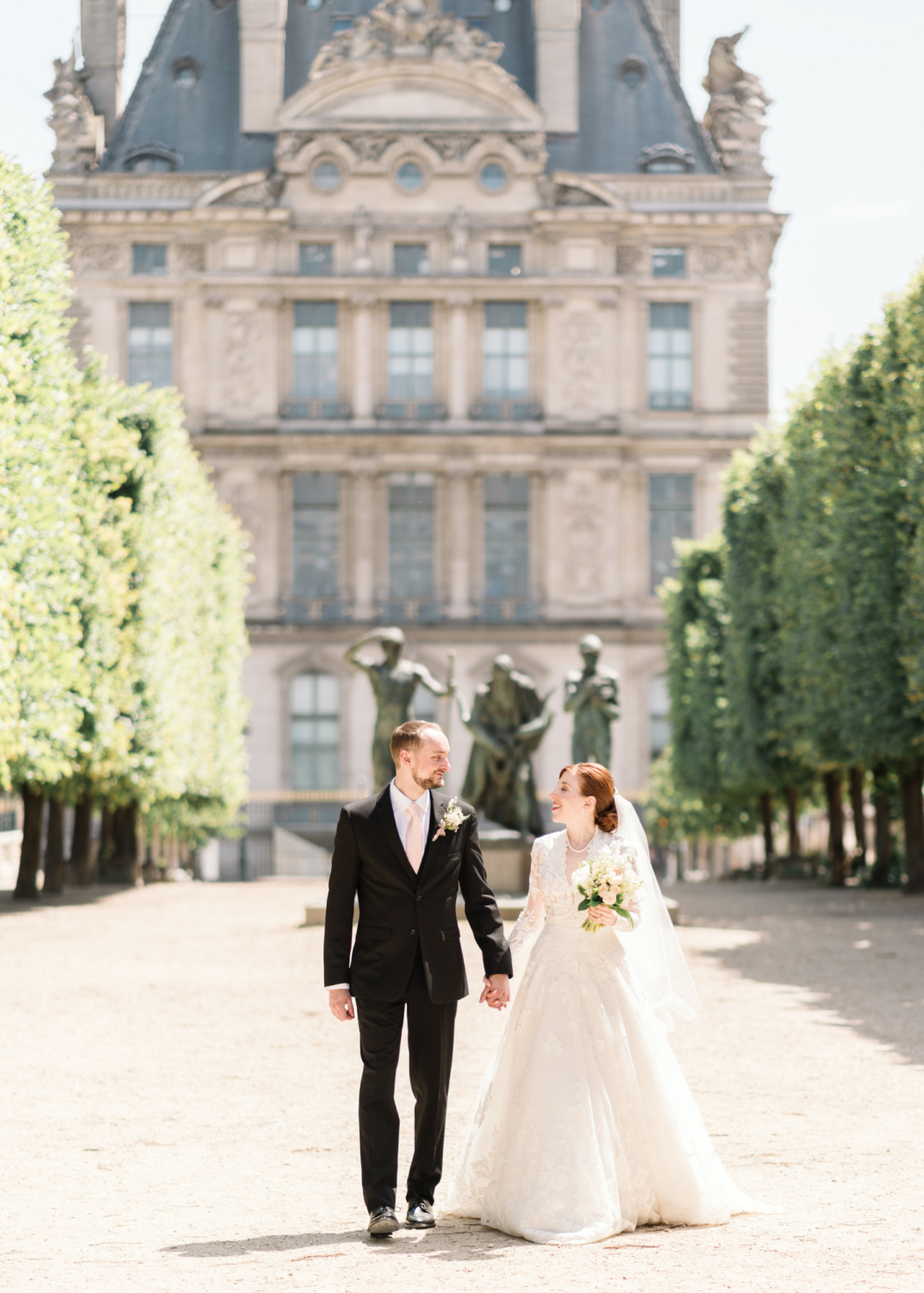 bride and groom walk through tuileries gardens on their wedding day