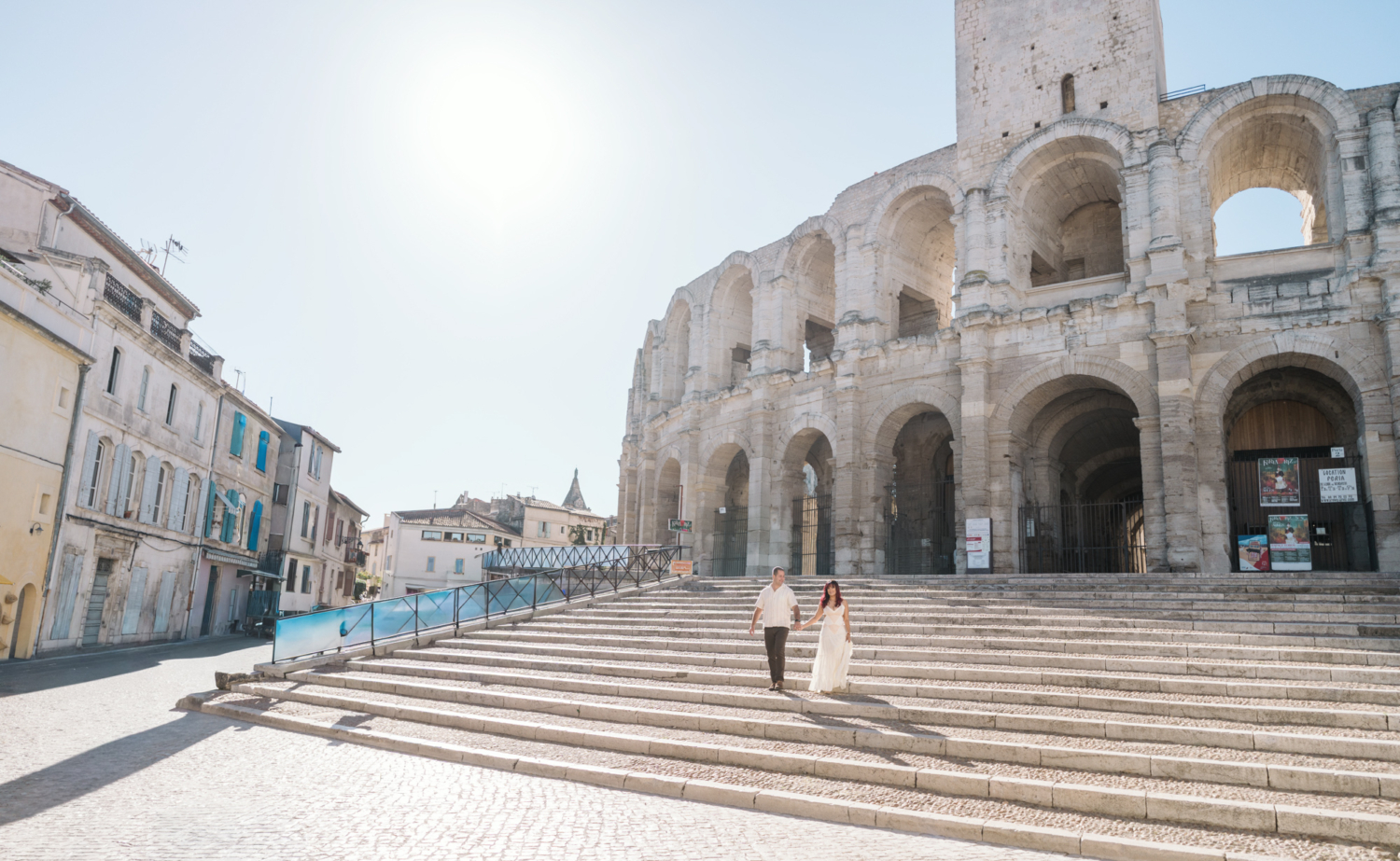 couple walk down the steps of roman amphitheater in arles france