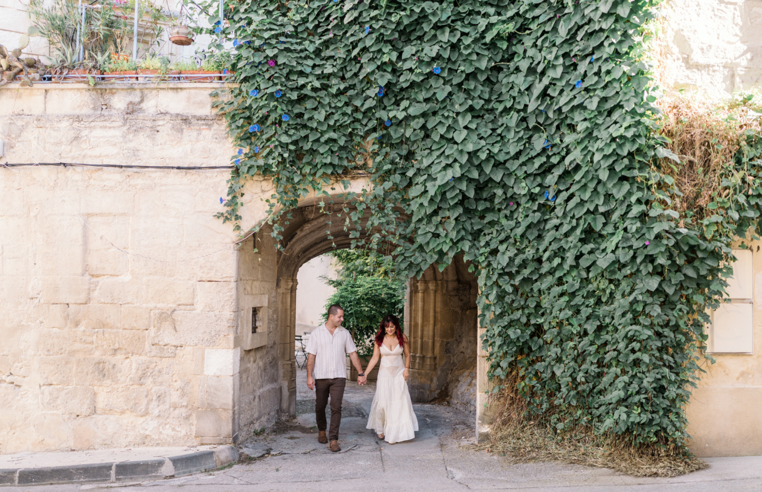 couple happily walk through archway in arles france