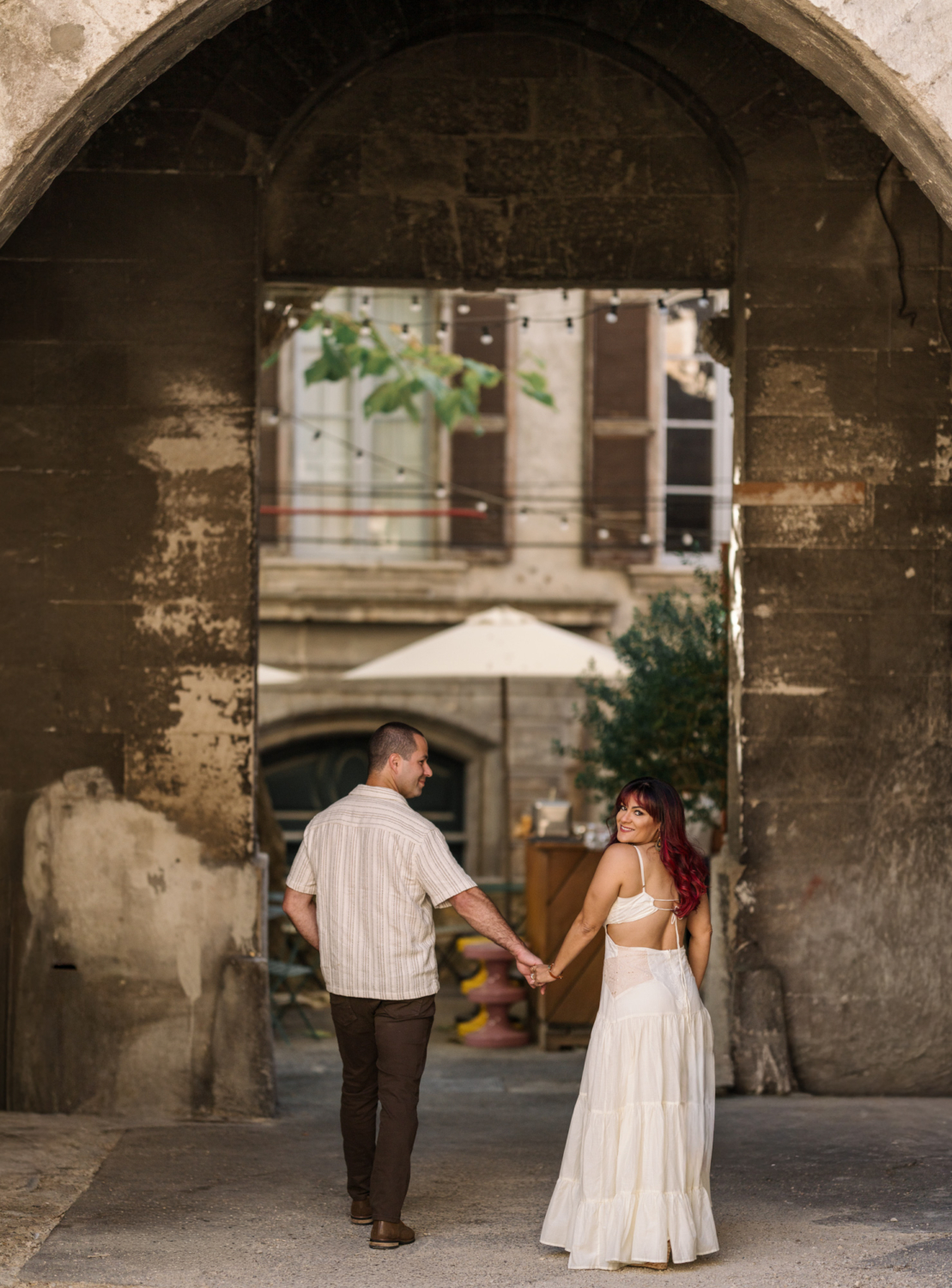 cute couple walk hand in hand in ancient arles france