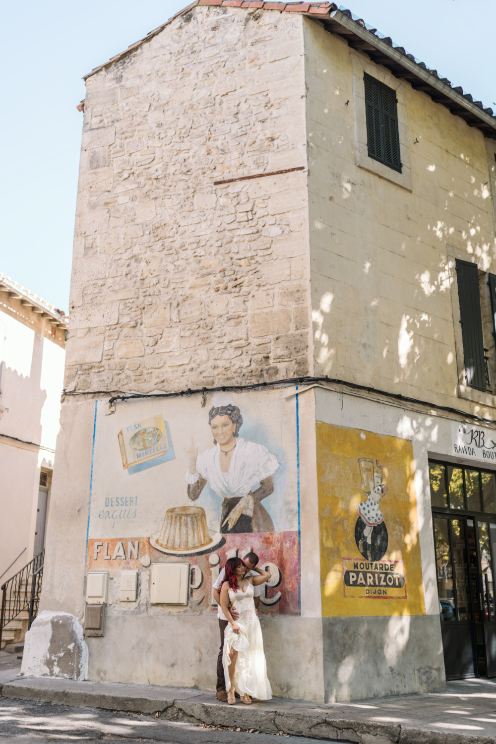 beautiful couple embrace in front of antique sign in arles france