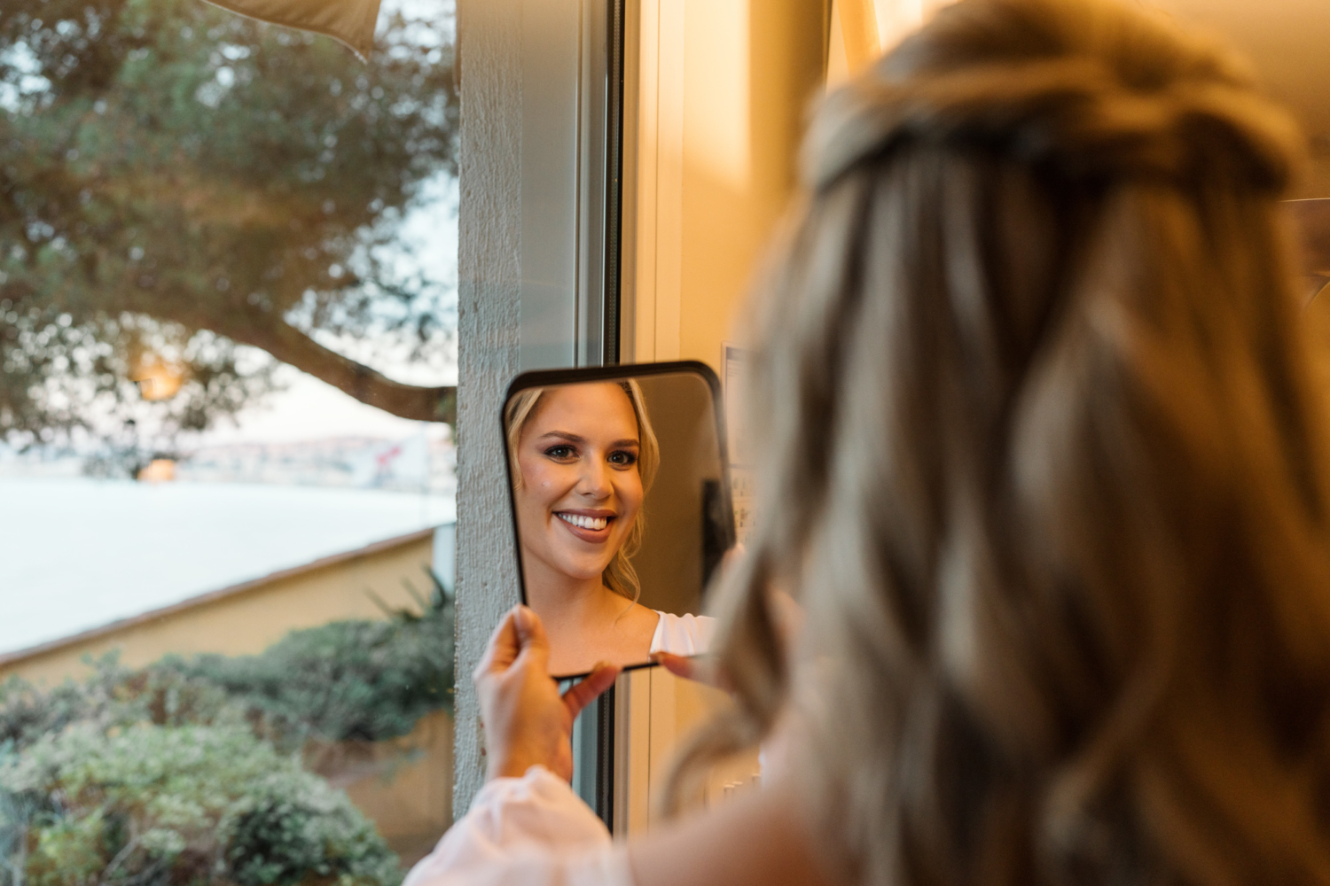 bride admires her wedding makeup in nice france