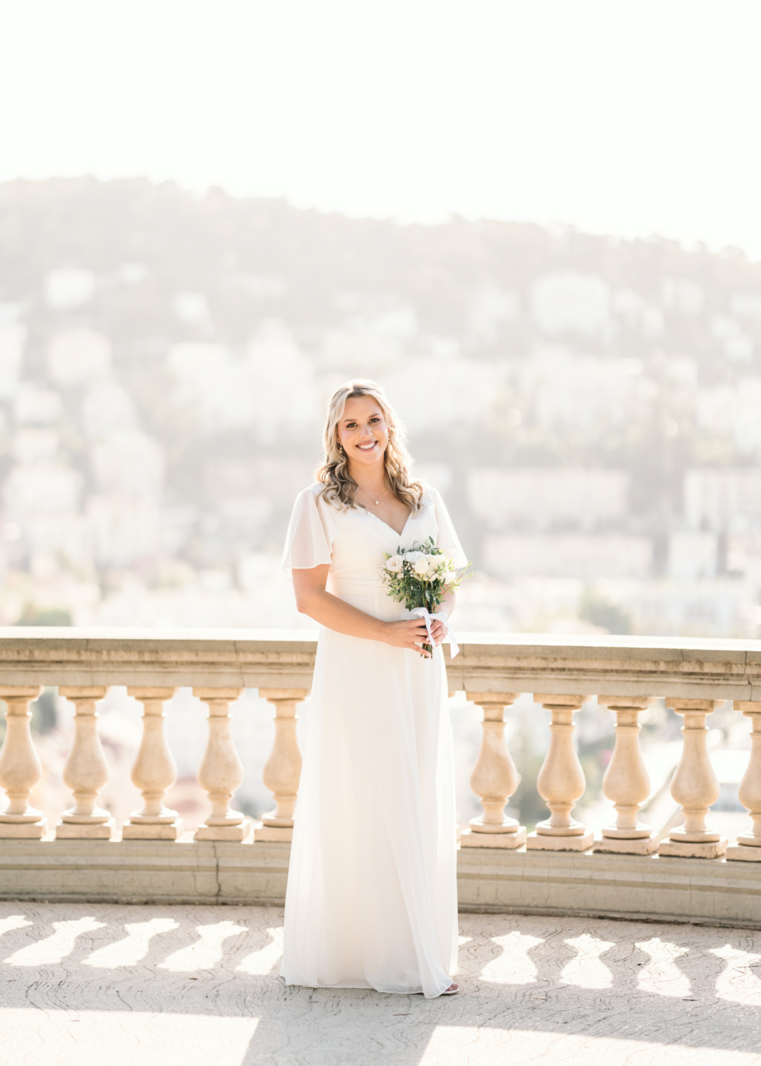 beautiful bride poses in the sunlight in nice france