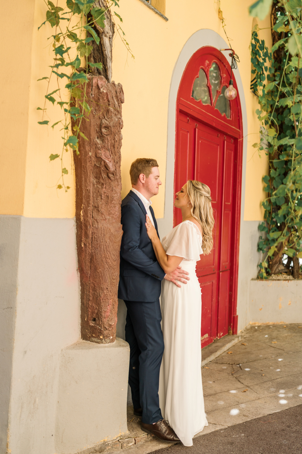 bride and groom pose outside red door in nice france