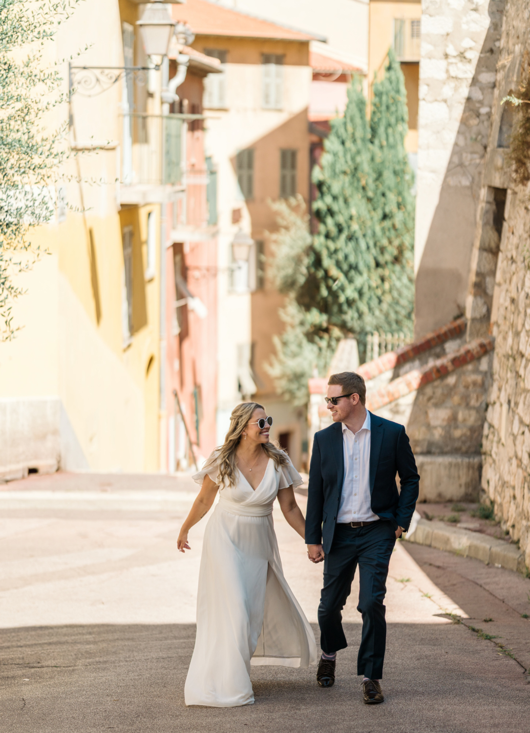 bride and groom walk hand in hand in old town nice france