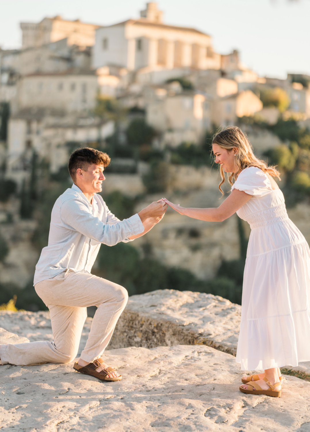 man puts engagement ring on woman's finger in gordes, france