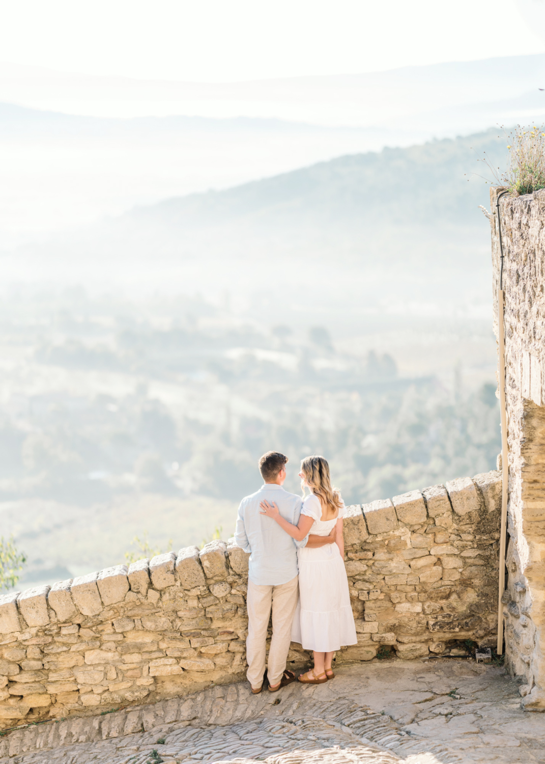 engaged couple embrace at sunrise in gordes, provence france