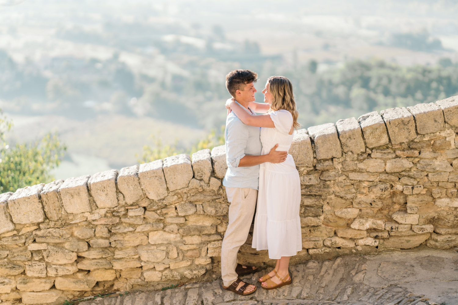 engaged couple embrace at sunrise in gordes, provence france